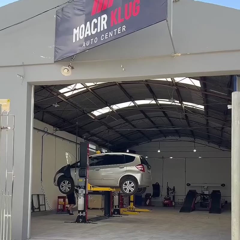 Fachada da oficina, com a placa Moacir Klug Auto Center e o portão aberto